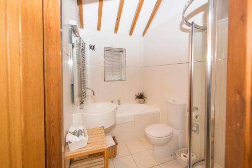 a white bathroom with a toilet and a sink at The Blue Bell Inn in Weaverthorpe