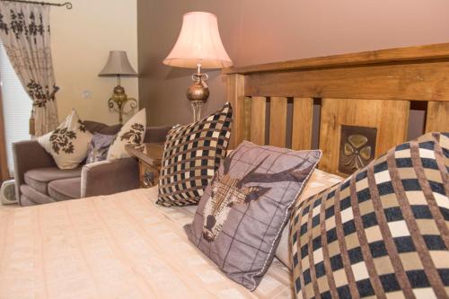 a bedroom with a bed with pillows and a couch at The Blue Bell Inn in Weaverthorpe