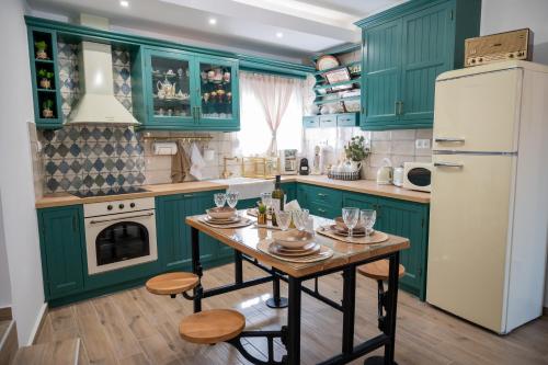 a green kitchen with a table and a refrigerator at Stoa Luxury House with Unique Jacuzzi Room in Mourné