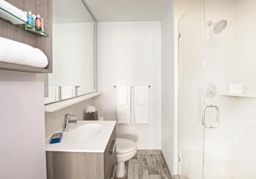 a bathroom with a toilet and a sink and a shower at Blue Moon Hotel in Miami Beach