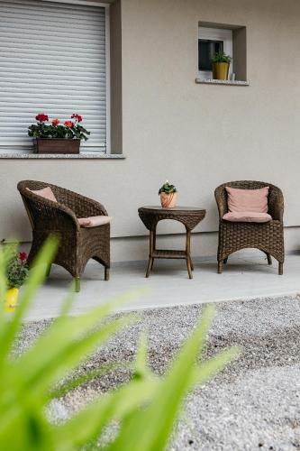 a patio with two chairs and a table and a window at Apartments Šentvid in Ljubljana