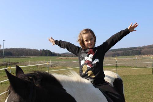 a young girl riding on top of a horse at Sonnenhof Ottrau in Ottrau
