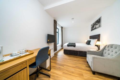 a hotel room with a bed and a desk with a desk at Simple Stay in London