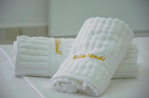 een stapel witte handdoeken zittend op een tafel bij Hotel Landi in Ksamil