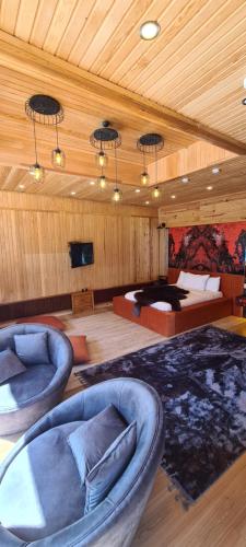 a room with two chairs and a bed and a television at Ayder Doga Resort in Ayder Yaylasi