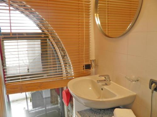 un baño con lavabo y espejo en Asti, en Gravedona