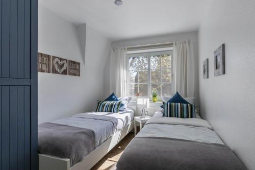 zwei Betten in einem Zimmer mit Fenster in der Unterkunft Ferienwohnung Kille-rechte Wohnung in Sankt Peter-Ording