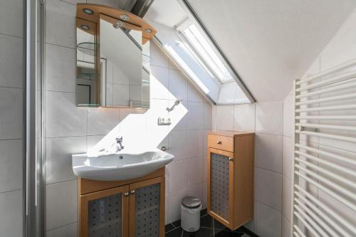 a bathroom with a sink and a skylight at Ferienwohnung Kille-rechte Wohnung in Ording