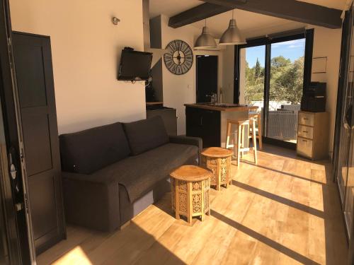 ein Wohnzimmer mit Couch und Küche in der Unterkunft Détente à Lorgues avec piscine privée in Lorgues