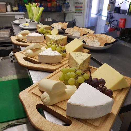 a bunch of cheese and grapes on a cutting board at The Blue Bell Inn in Weaverthorpe