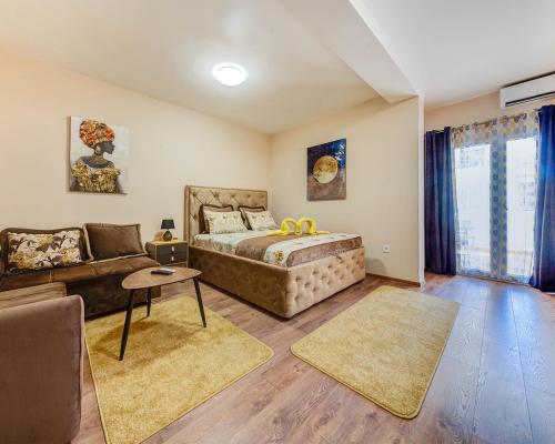 - une chambre avec un lit et un canapé dans l'établissement Dom B Apartments, à Budva