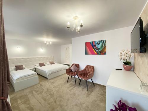 a hotel room with two beds and a tv at Casa Ina in Moisei