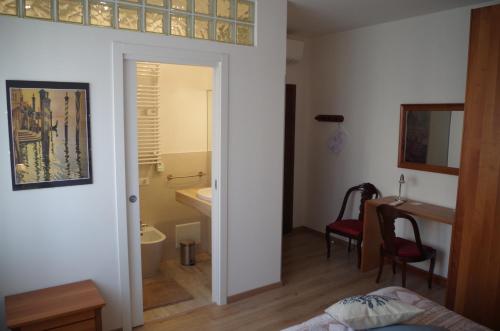 Cette chambre comprend un lit, un bureau et une salle de bains. dans l'établissement Alla Torre B&B, à Mestre