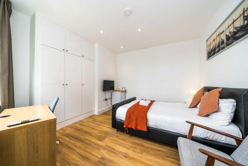 a bedroom with a bed and a desk and a chair at Simple Stay in London