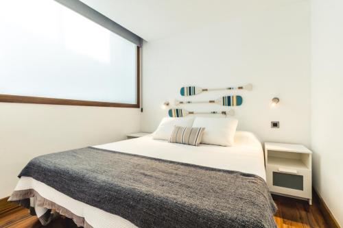 A bed or beds in a room at Melenara Beach Avenue Apt Shared Terrace