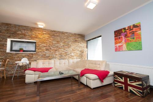 a living room with a couch and a brick wall at Apartments Klinovec in Loučná pod Klínovcem