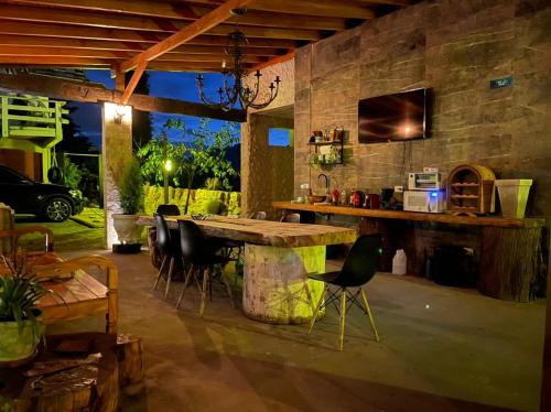 a room with a stone wall with a table and chairs at Campos House in Campos do Jordão