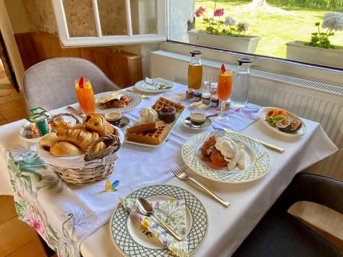 una mesa con platos de comida en una mesa en Sans Souci Bed and Breakfast Luxe Heated Pool and Restaurant, en Luzillé