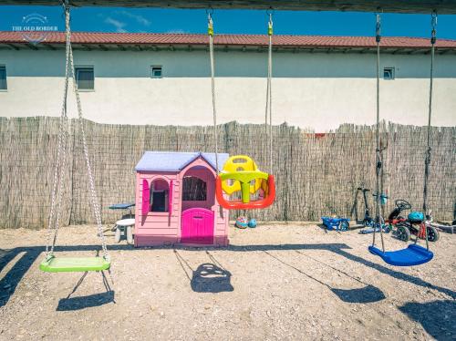 a playground with a swing set and a swing at The Old Border in Vama Veche
