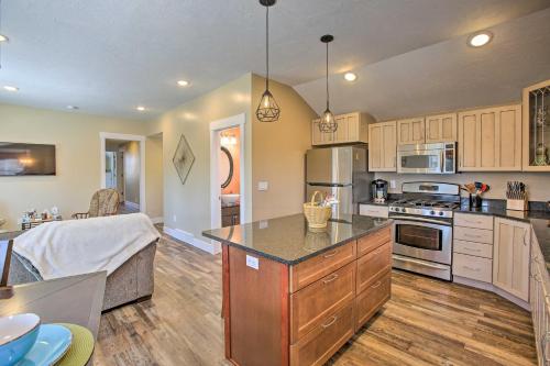 a large kitchen with wooden cabinets and a large island at Cozy and Urban Ludington Apt about 1 Mi to Lake Michigan in Ludington