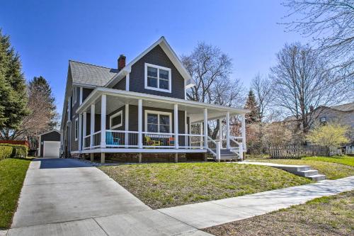 a house with a large porch on a lawn at Cozy and Urban Ludington Apt about 1 Mi to Lake Michigan in Ludington
