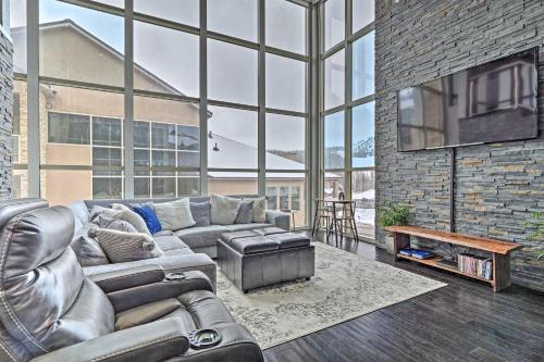 a living room with a leather couch and a tv at Luxe Brian Head Escape with Hot Tub and Mtn Views in Brian Head