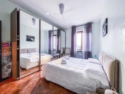 1 Schlafzimmer mit 2 Betten und einem großen Spiegel in der Unterkunft MYHOUSE INN LINGOTTO - Affitti Brevi Italia in Turin