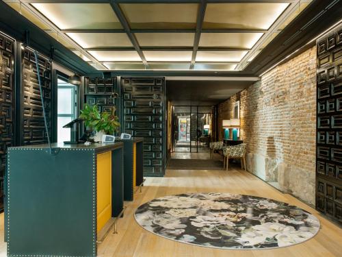 a hallway with a brick wall and a rug at Pestana Collection Plaza Mayor in Madrid