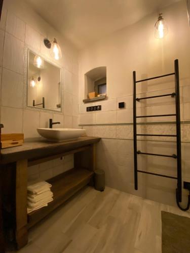 ein Bad mit einem Waschbecken und einem Spiegel in der Unterkunft Biely domček so záhradou v malej obci Devičie in Devičie