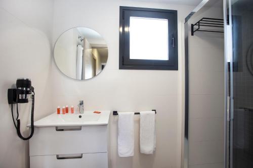 a white bathroom with a sink and a mirror at Apartamentos Maryciel By Mc in Benidorm