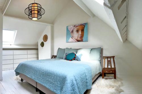 een slaapkamer met een bed met een blauw dekbed bij Rosier37 in Antwerpen