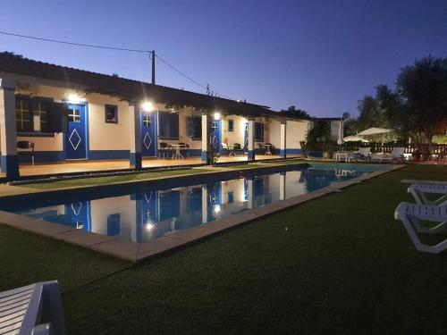 a swimming pool in front of a house at night at Monte Família Ferreira in Vale de Açor