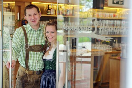 un hombre y una mujer de pie junto a un refrigerador en Perbersdorfer Heuriger en Neuhofen an der Ybbs