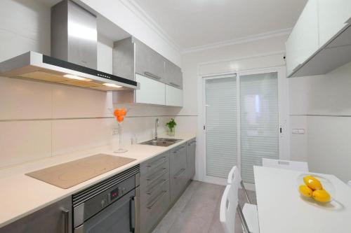 eine weiße Küche mit einer Spüle und einer Theke in der Unterkunft Casa Mediterraneo in Alcúdia
