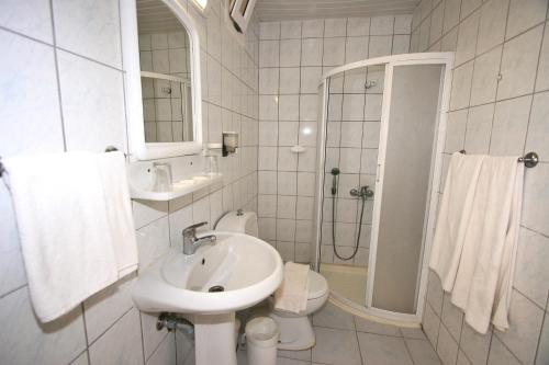 Baño blanco con lavabo y aseo en Greenport Bodrum Hotel, en Guvercinlik