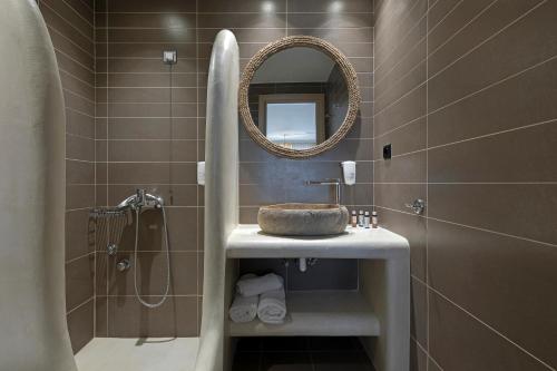 a bathroom with a sink and a mirror at Anastasia Hotel & Suites Mediterranean Comfort in Karistos