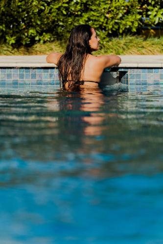 a woman in the water in a swimming pool at Hotel RH Boutique Aruba in Oranjestad