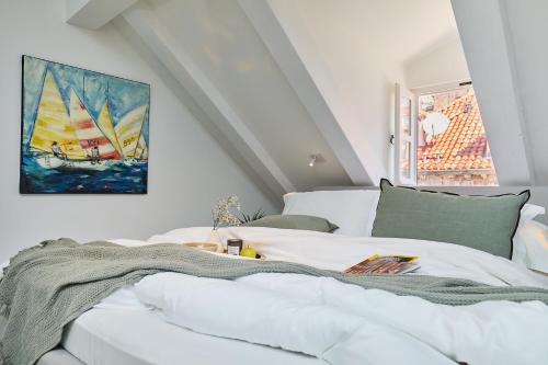 a bedroom with a white bed with a painting on the wall at Bota Palace in Dubrovnik