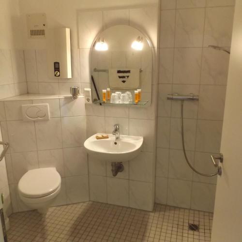 a bathroom with a toilet and a sink and a shower at Ostsee-Residenz 17 in Damp