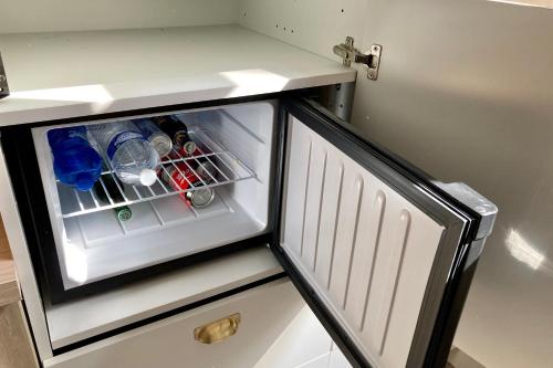 - un petit réfrigérateur avec une porte ouverte dans la cuisine dans l'établissement OXXOTEL, à Valognes