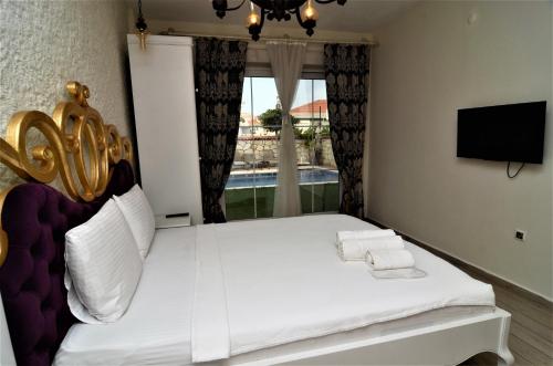a bedroom with a white bed with a large window at Grand Alaçatı Butik Hotel in Alacati