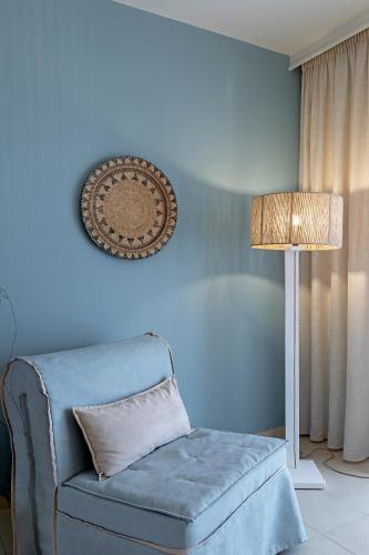 a blue room with a chair and a lamp at Anastasia Hotel & Suites Mediterranean Comfort in Karistos