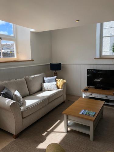 a living room with a couch and a coffee table at The Old English Rooms in Falmouth