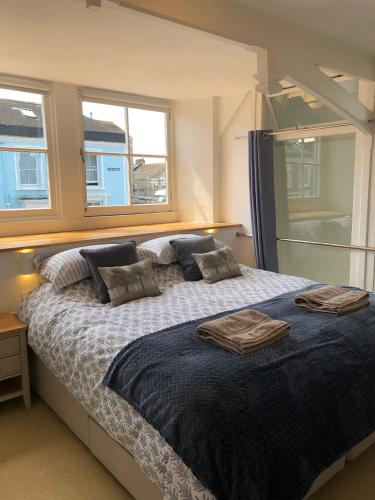 a bedroom with a bed with two towels on it at The Old English Rooms in Falmouth