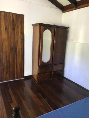 a room with a wooden cabinet and a mirror at FLOR DE PARAISO BUNGALOWS in Montezuma