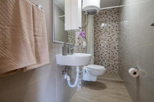 un bagno con lavandino e WC di Apartmani Frane a Neum
