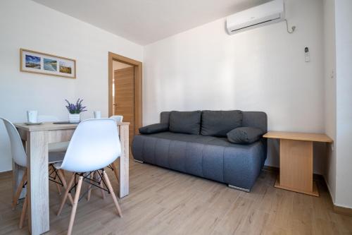 un salon avec un canapé et une table dans l'établissement Apartmani Frane, à Neum