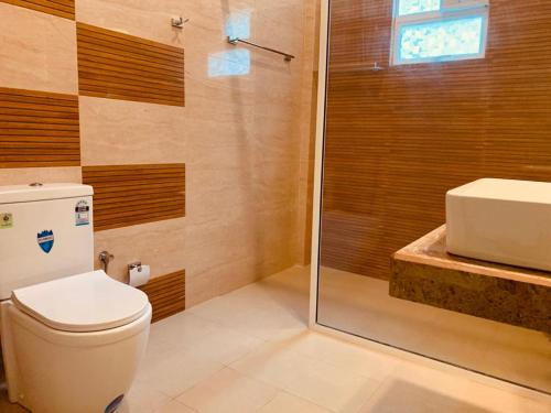 a bathroom with a toilet and a shower and a sink at Elegant Lake Yala Safari House in Tissamaharama