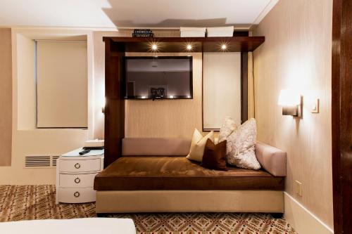 a hotel room with a bed with a tv on the wall at City Club Hotel in New York