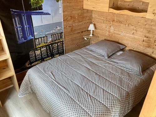 a bedroom with a bed with a wooden wall at Studio CAP-OCEAN cap ferret in Cap-Ferret